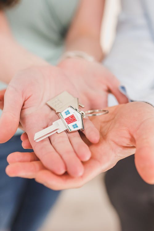 Free People Holding a House Shaped Key Stock Photo