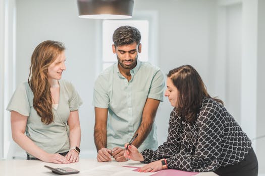 Three professionals engaged in a discussion indoors, possibly real estate related.