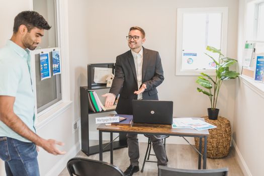 A professional business interaction in a modern office with a mortgage broker and client.