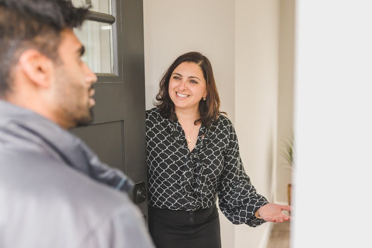 A Realtor Welcoming A Client Into The House