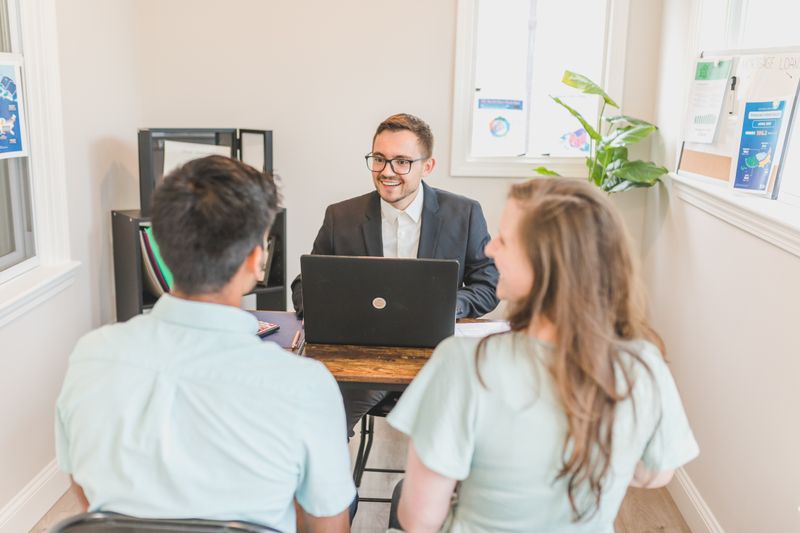 Couple consulting with a real estate agent in an office about buying a new home