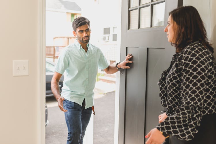 A Man Talking To A Woman On A Doorway