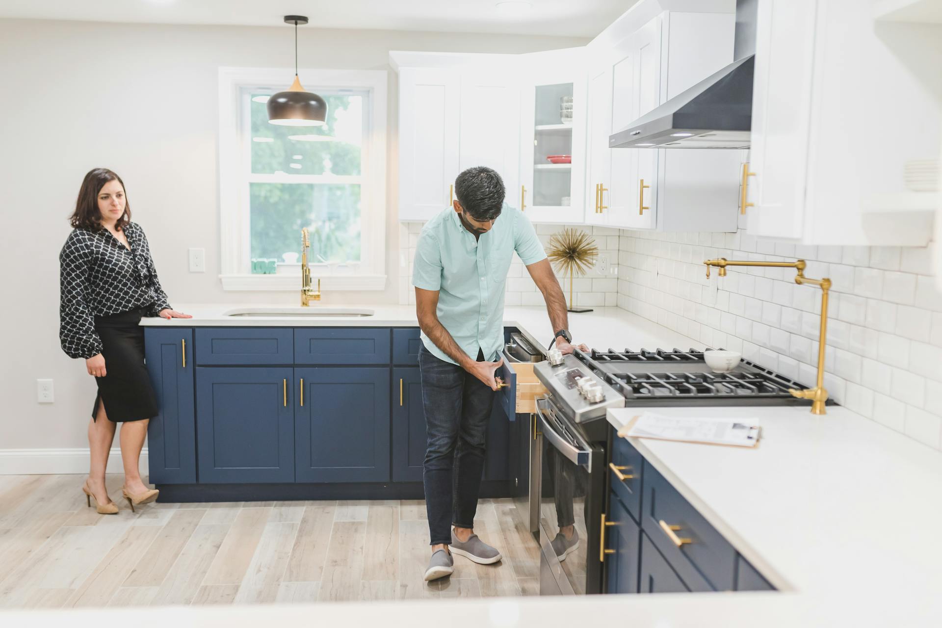 Real estate agents inspecting a modern kitchen interior for potential sale.