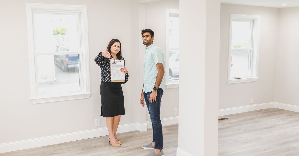 A real estate agent showing a potential buyer the interior of a new home.