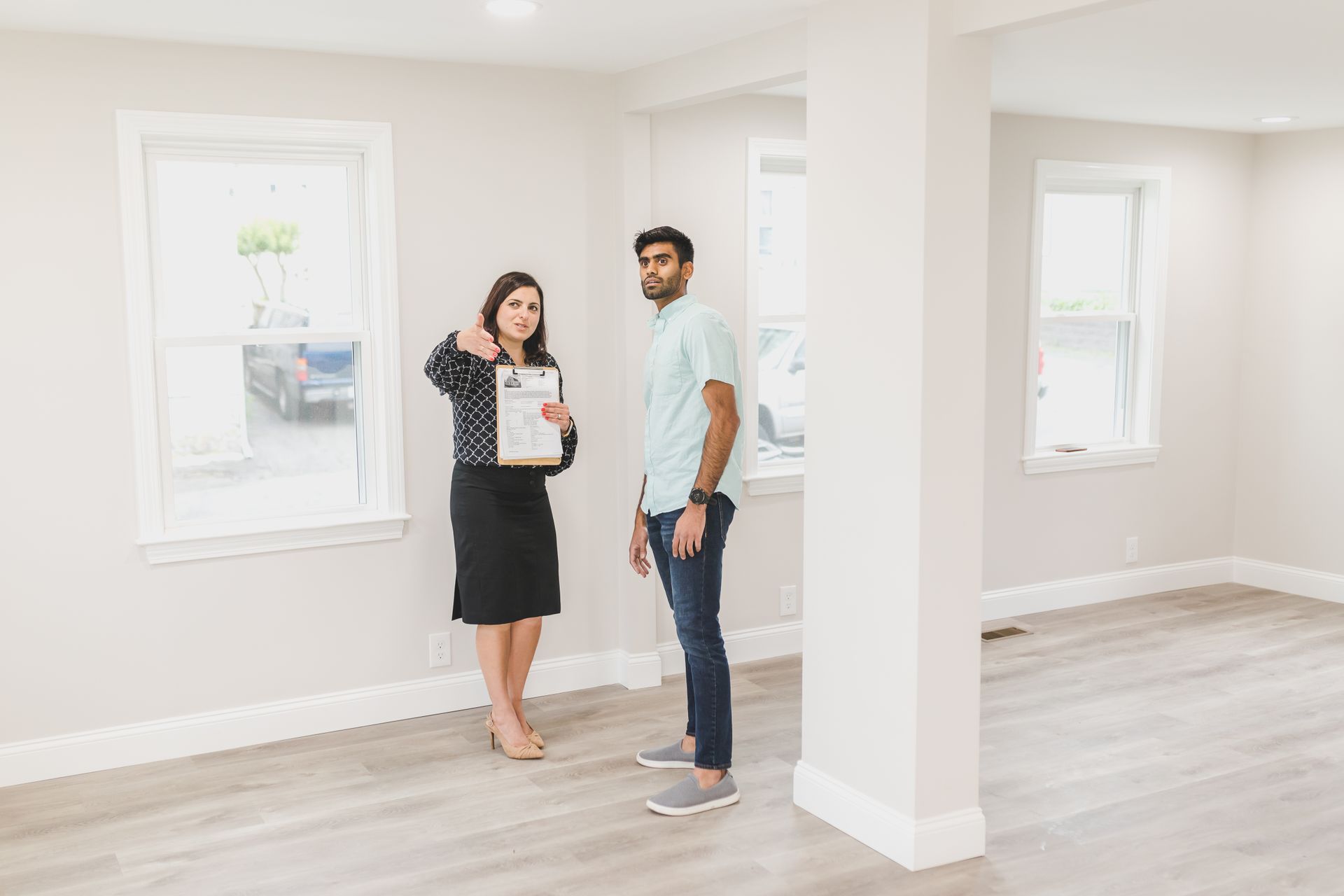 Estate agent walking through a living room with the owners