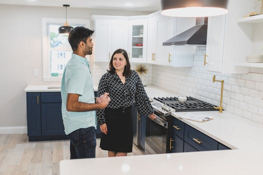 Couple exploring a modern kitchen space during a real estate tour.