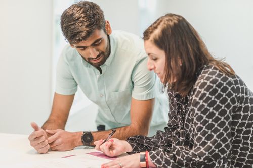 Free A real estate agent assists a client with home buying paperwork indoors. Stock Photo