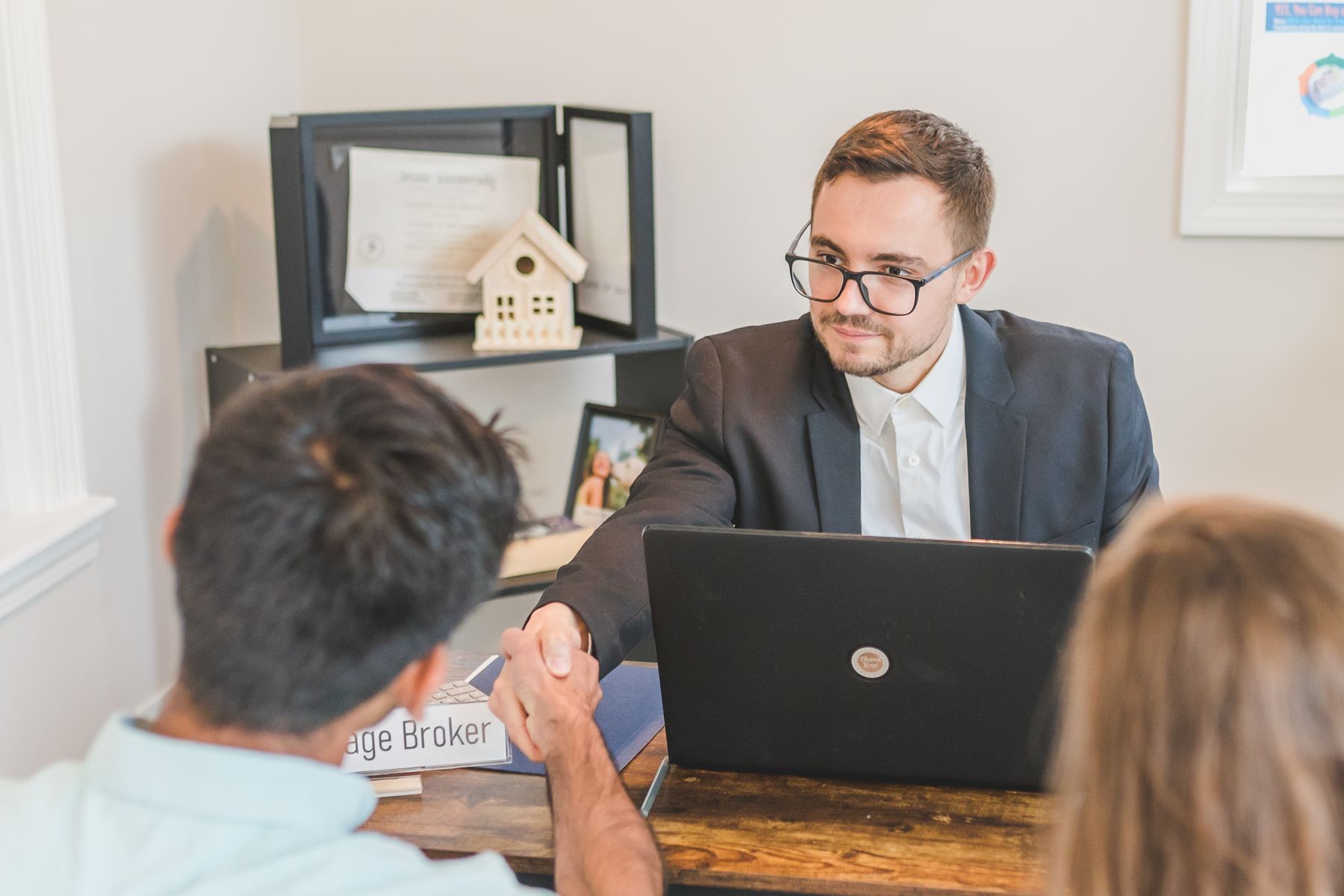 Mortgage broker reviewing borrower documents with a family