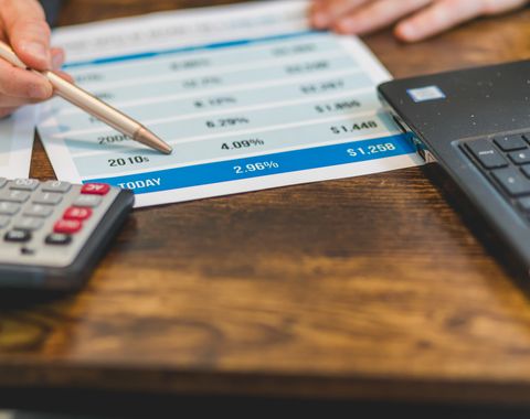 Contador analizando cifras con calculadora y laptop para la contabilidad de una PYME