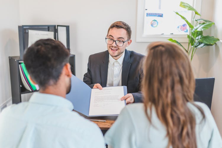 A Broker Showing A Couple The Mortgage Contract