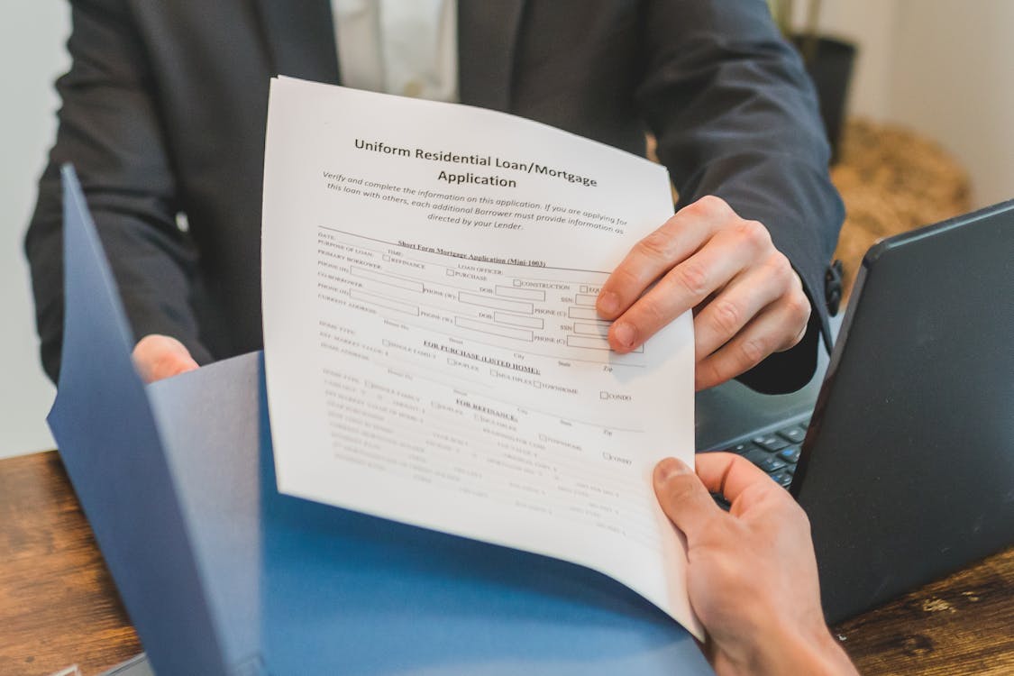 Free A Person Handing over a Mortgage Application Form Stock Photo