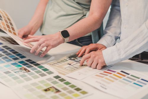 Free Two people planning a project with color palettes on a table, collaborating creatively. Stock Photo