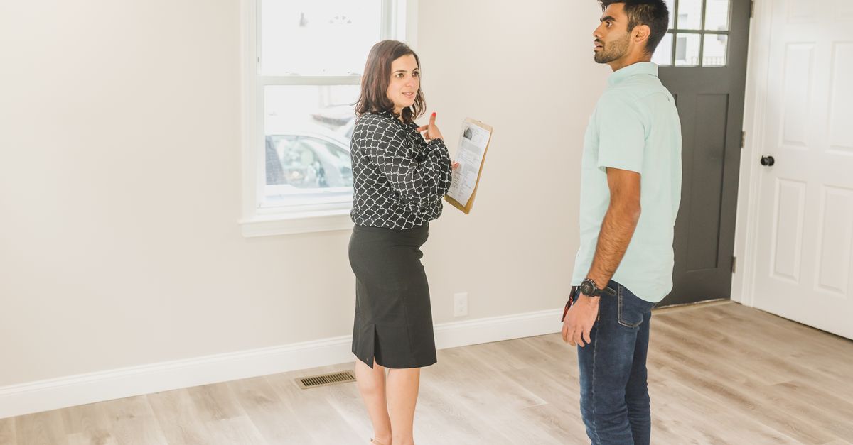 Real estate agent showing a modern home interior to a potential buyer.