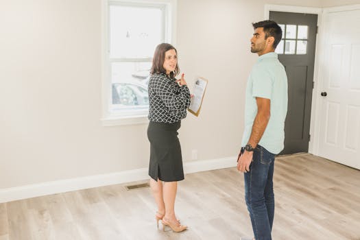 Real estate agent showing a modern home interior to a potential buyer.