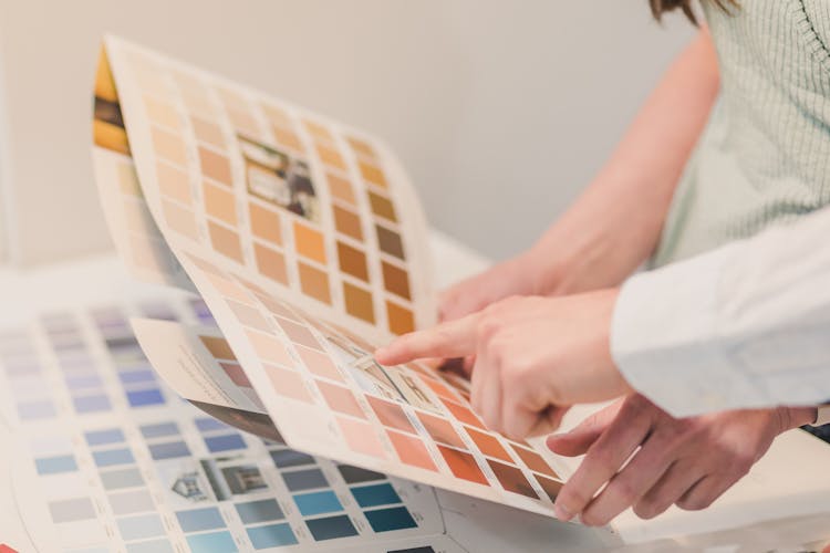 Two People Choosing Color Of Paint In A Brochure