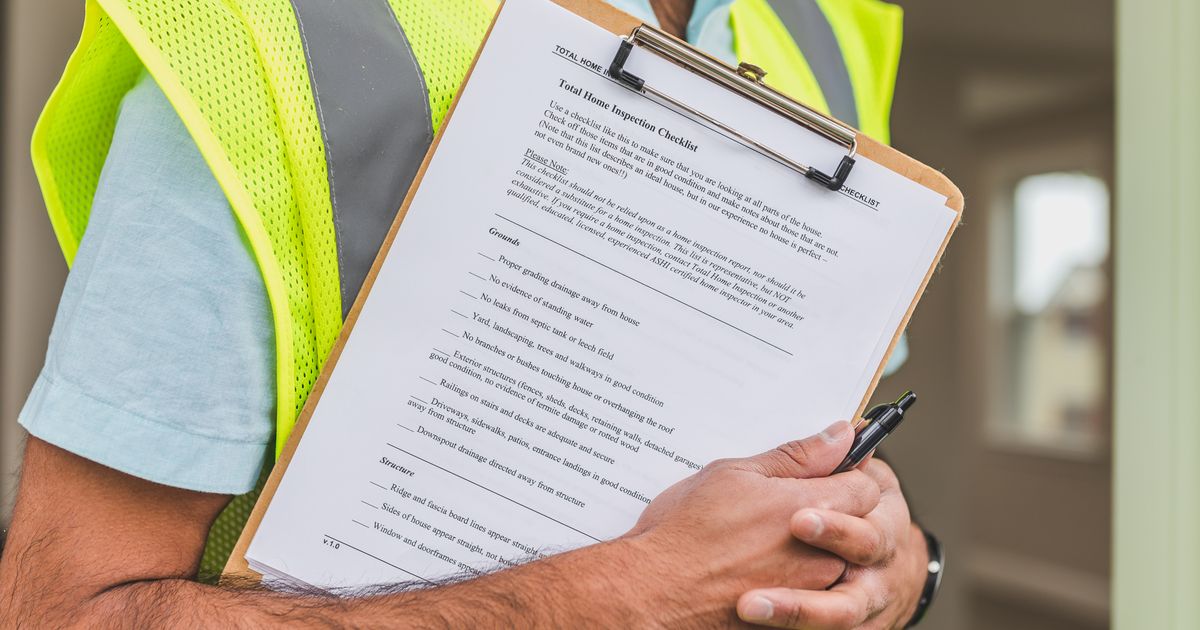 Hand mit Klemmbrett und Checkliste bei einer Objektbegehung – Qualitätskontrolle in der Gebäudereinigung