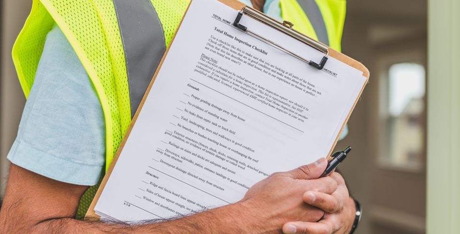 Inspector with a clipboard checking a property — termite work starts with a proper inspection