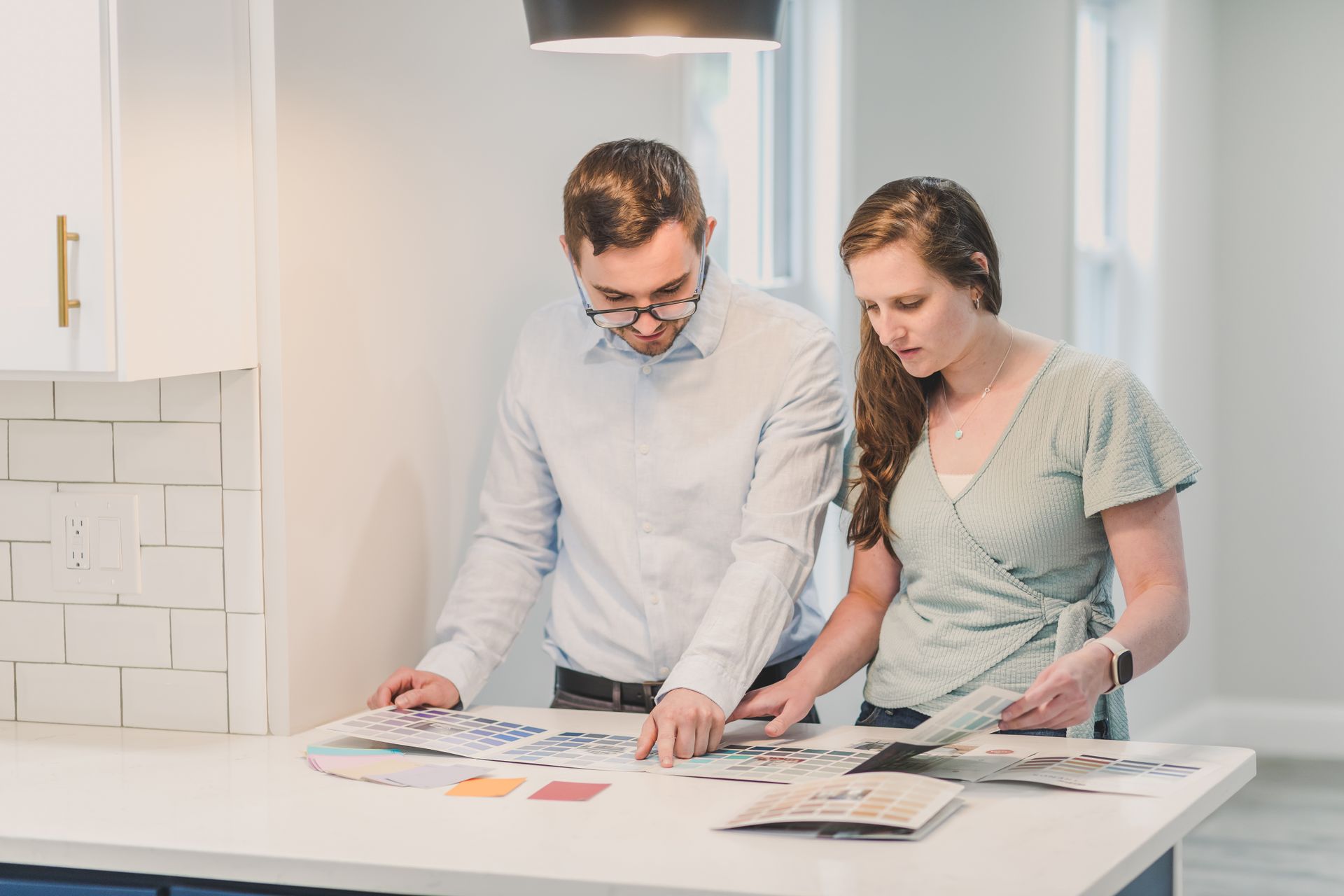A couple selecting color swatches for home decoration, symbolizing planning and collaboration.