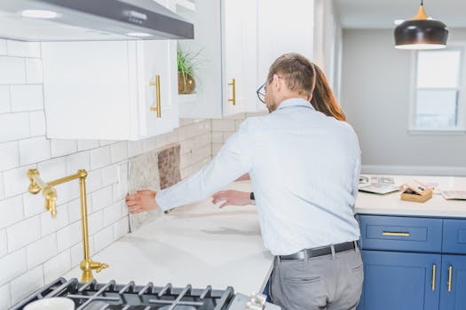A couple choosing tiles in a modern kitchen setting, discussing renovation ideas.
