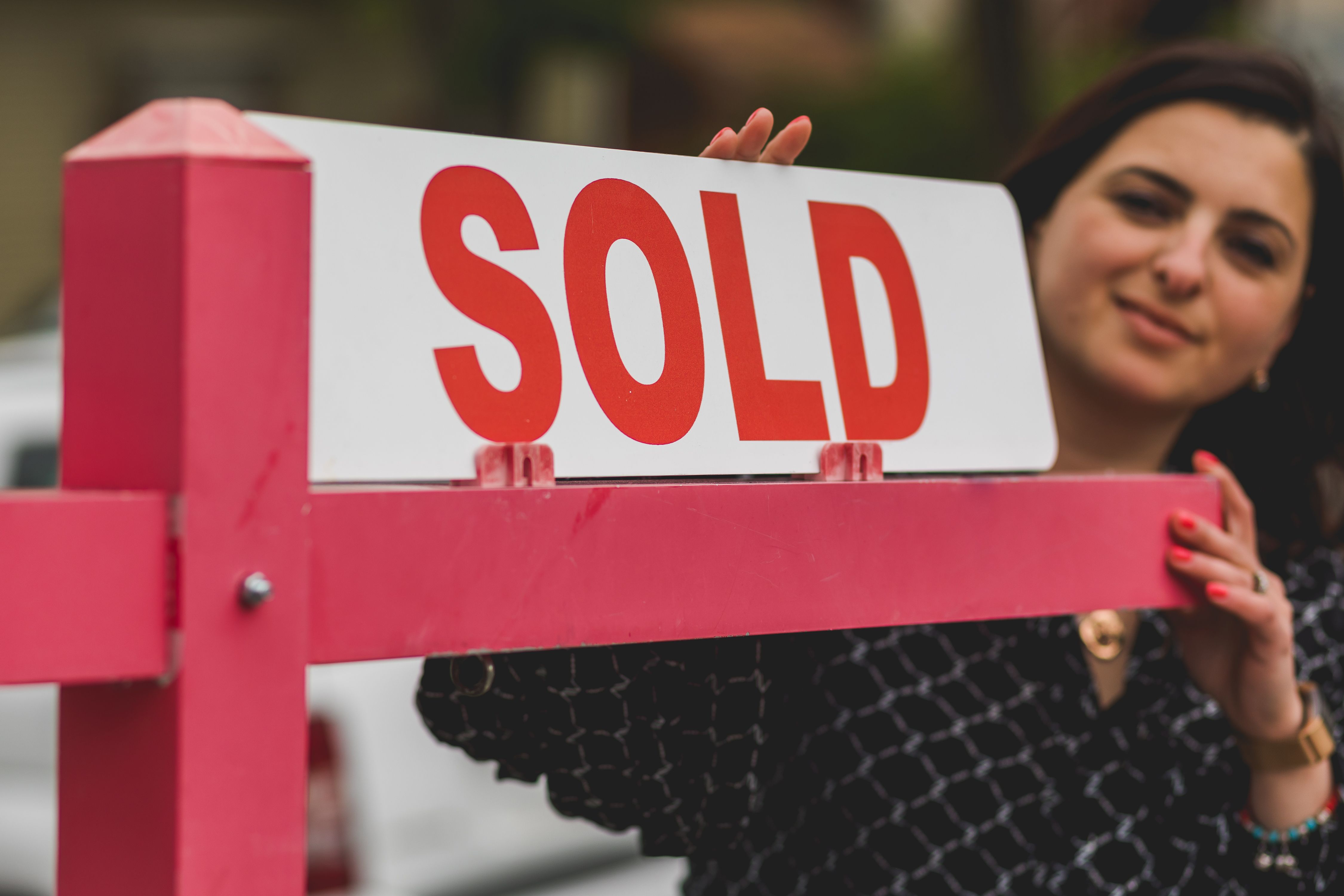 Owner Builder Permit QLD: Requirements, Costs and How to Apply 8 Real estate agent holding a sold sign outside a residential property
