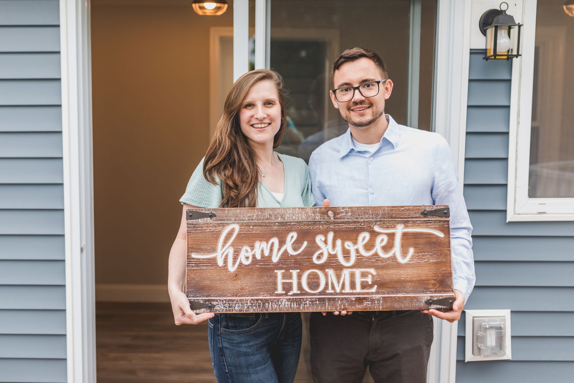 Couple Holding a Wooden Home Sweet Home Sign