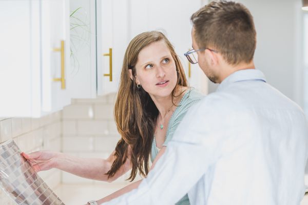 Two people comparing tile samples in a bright kitchen — photo by RDNE Stock project on Pexels