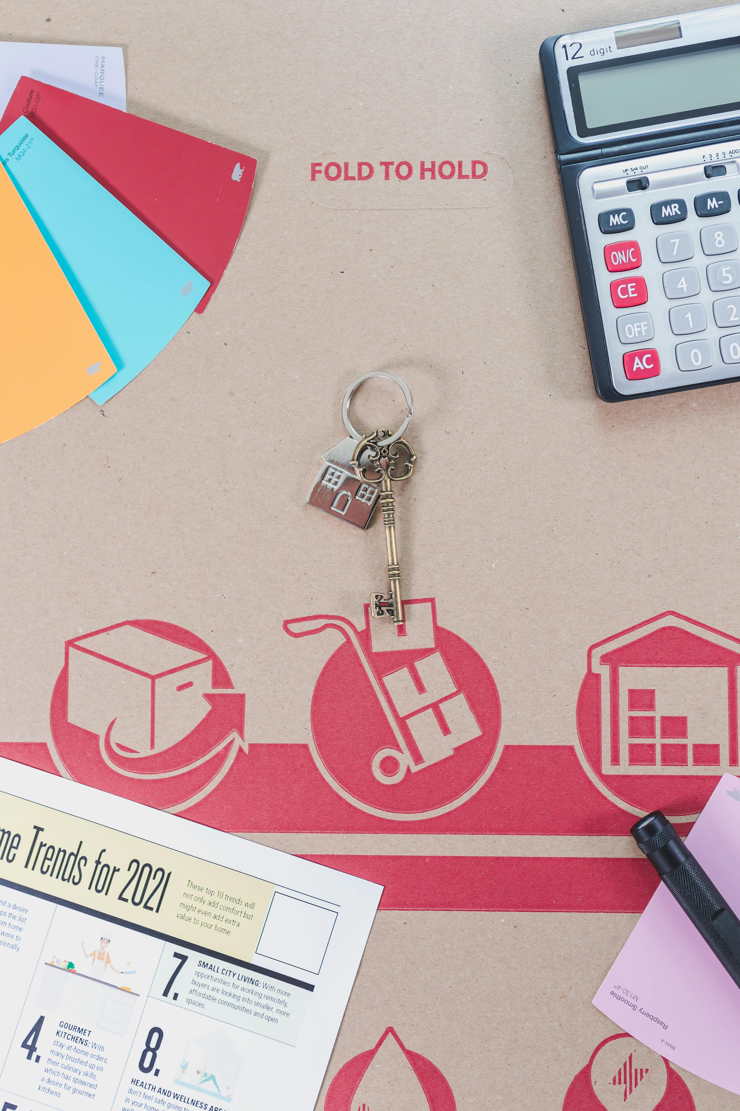 key on cardboard beside a calculator and brochure