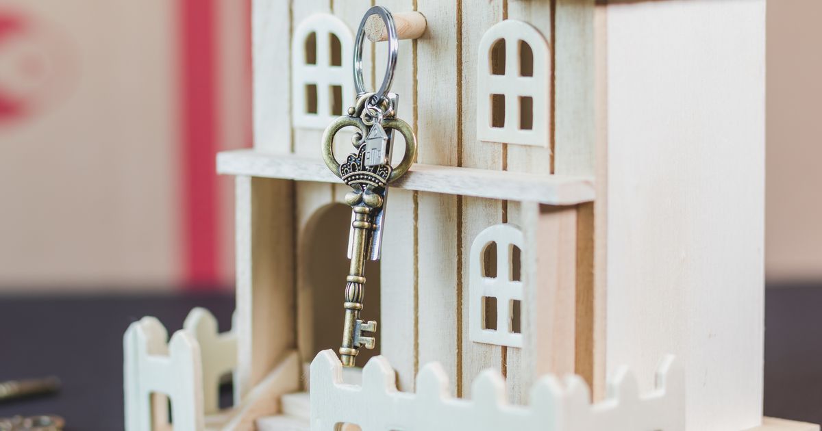 Maison en bois miniature accompagnée d’une clé