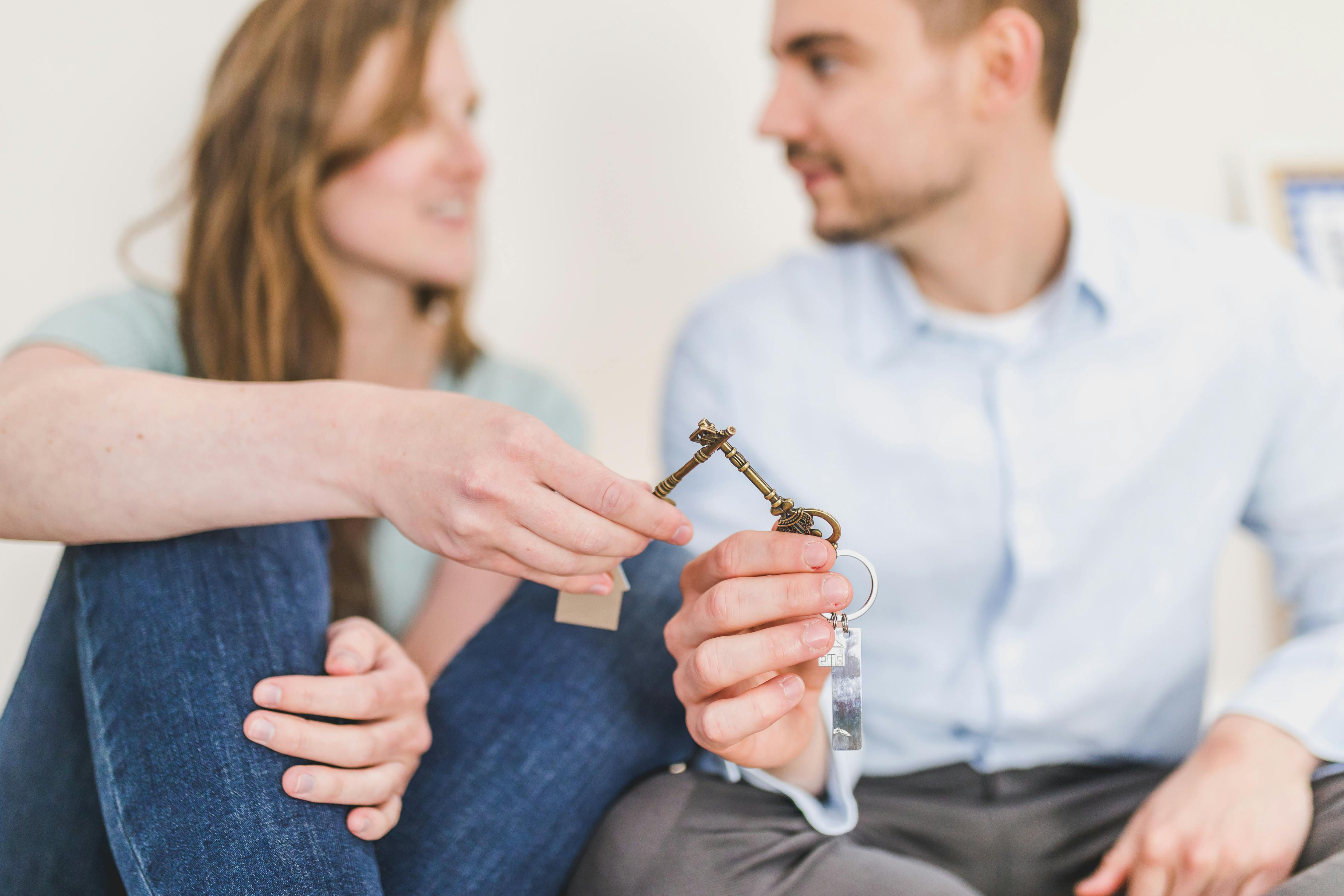 man and woman sitting while holding keys