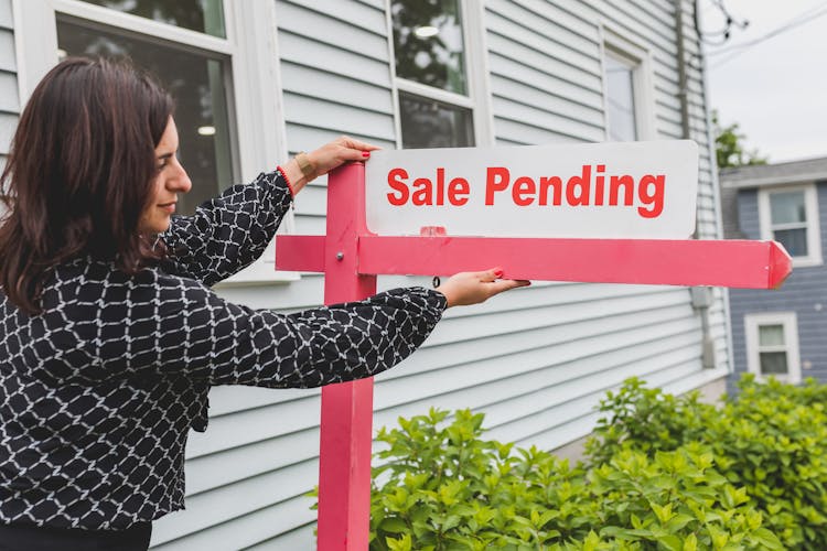 Real Estate Agent Holding A Signage