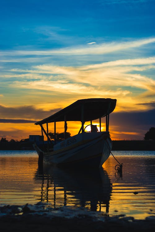 Boat Docked on Sea during Sunset