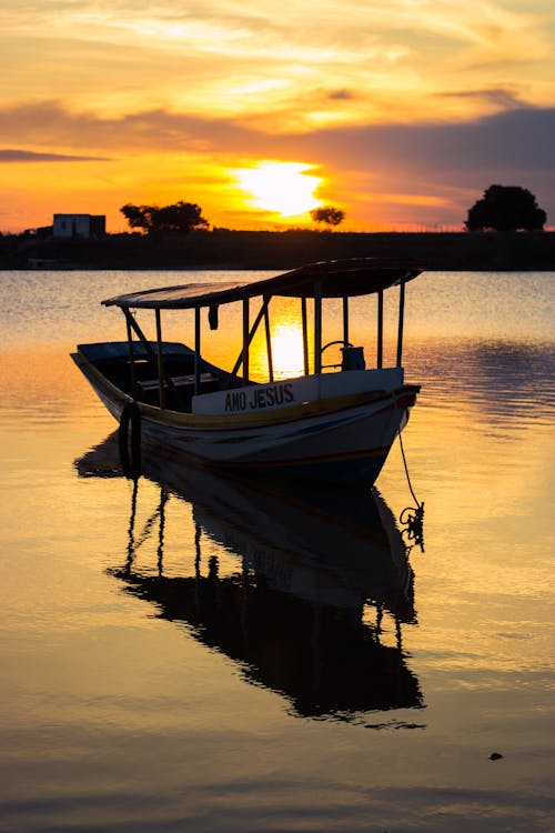 A Wooden Boat Sailing on the River During Beautiful Sunset