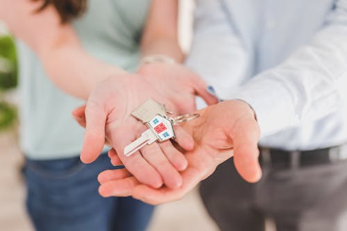 Free House Key on the People's Hand while Standing Next to Each Other  Stock Photo