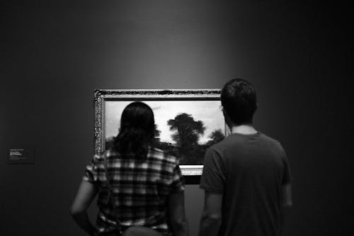People Looking at a Painting on a Wall