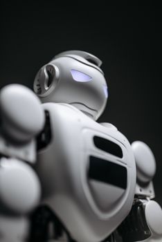Close-up of a futuristic robot with glowing blue eyes, showcasing advanced technology and design.