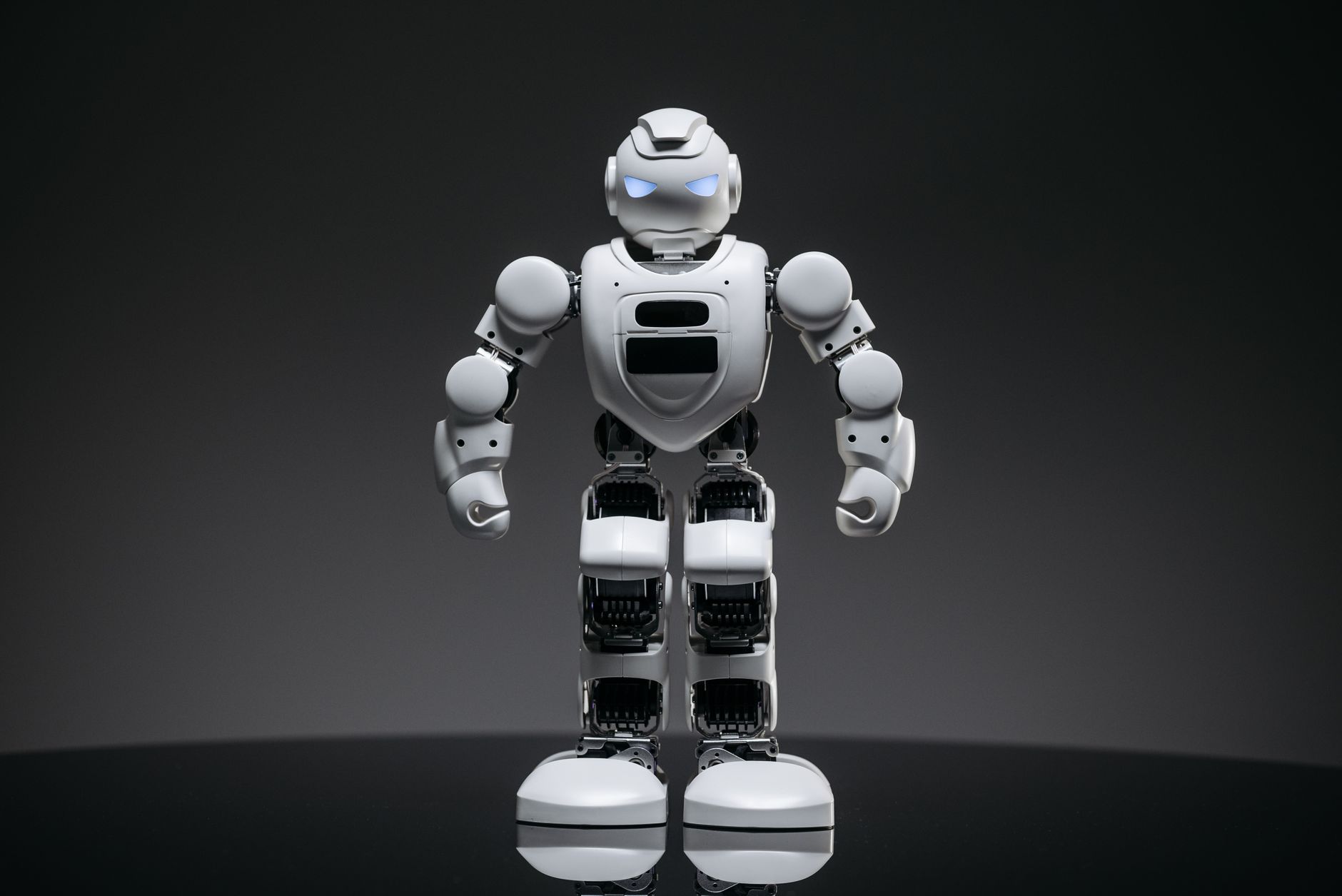 Close-up of a modern white robot with glowing eyes, symbolizing future technology and innovation.