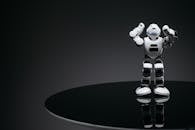 White Robot Toy on Round Black Table