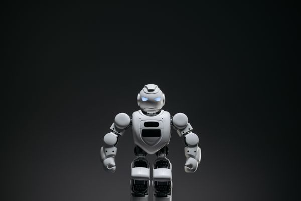 Small humanoid robot lit against a dark backdrop — photo by Pavel Danilyuk on Pexels