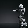 A sleek, white humanoid robot with visible mechanical joints against a dark studio background.