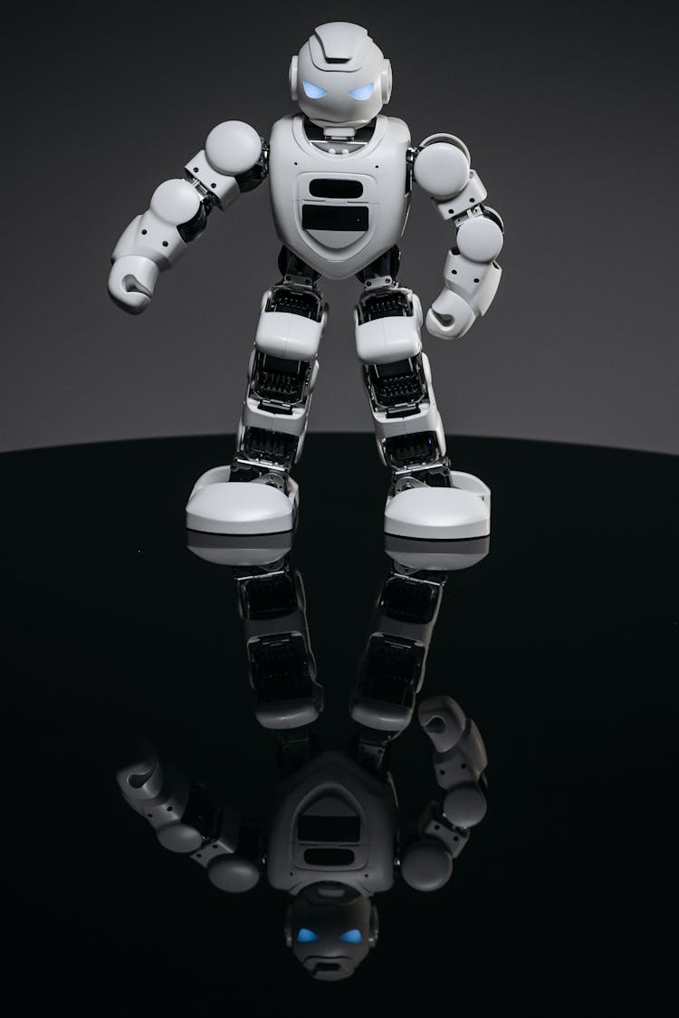 White Robot Toy On Black Surface