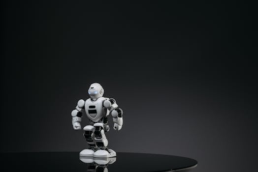 A small white robot stands on a reflective surface in a dark studio setting, showcasing modern technology.