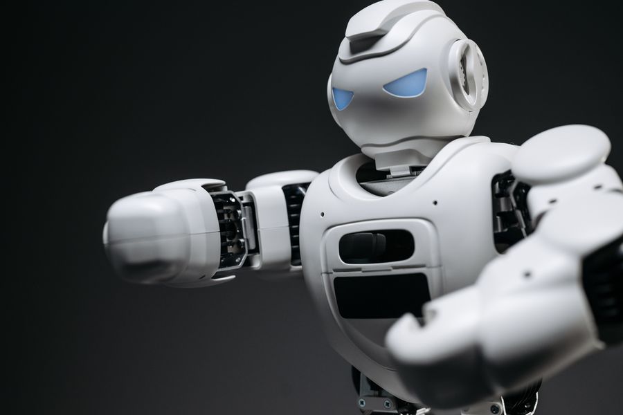 Detailed close-up of a high-tech white robot in a studio setting with a gray background.