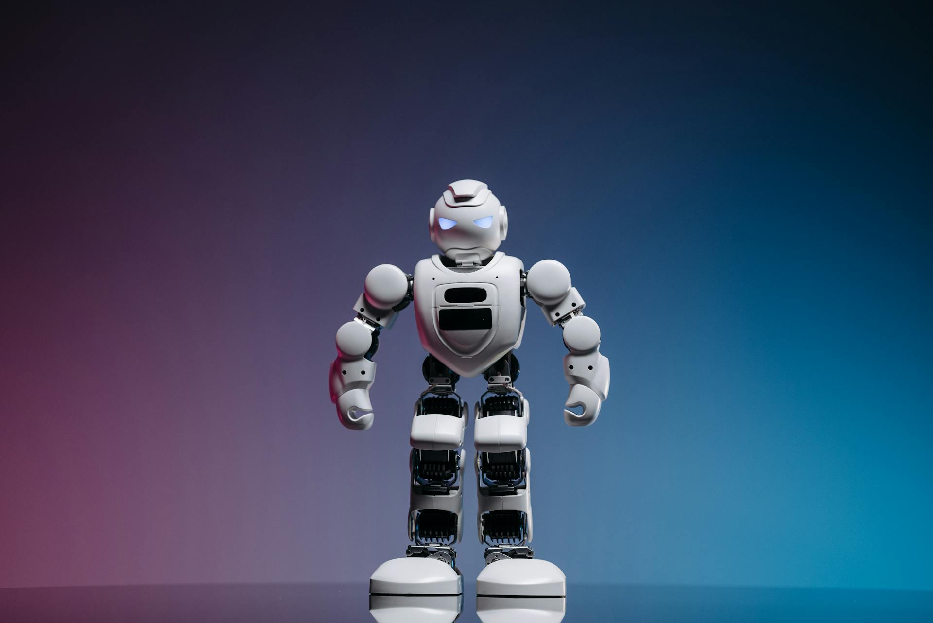 A modern toy robot standing on a gradient background, showcasing innovation and technology.