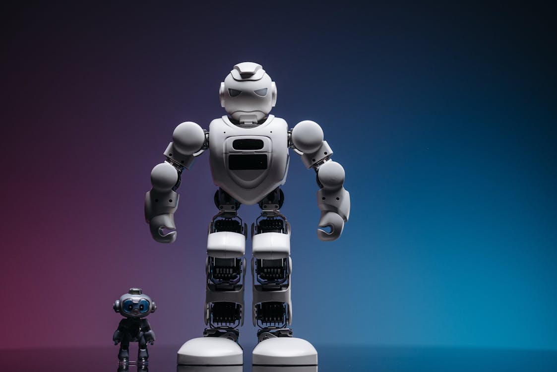 a white robot toy beside a miniature robot