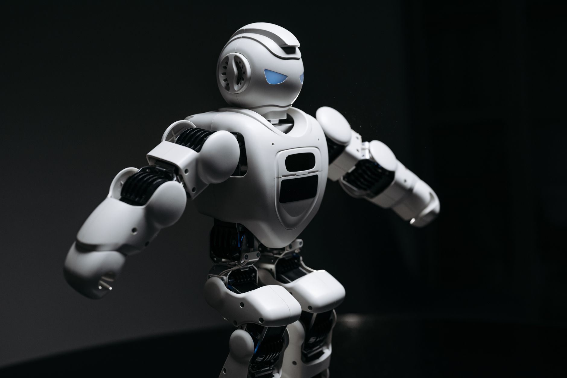 Close-up of a futuristic humanoid robot under dramatic lighting in dark ambiance.