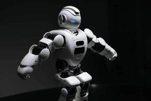 Close-up of a futuristic humanoid robot under dramatic lighting in dark ambiance.