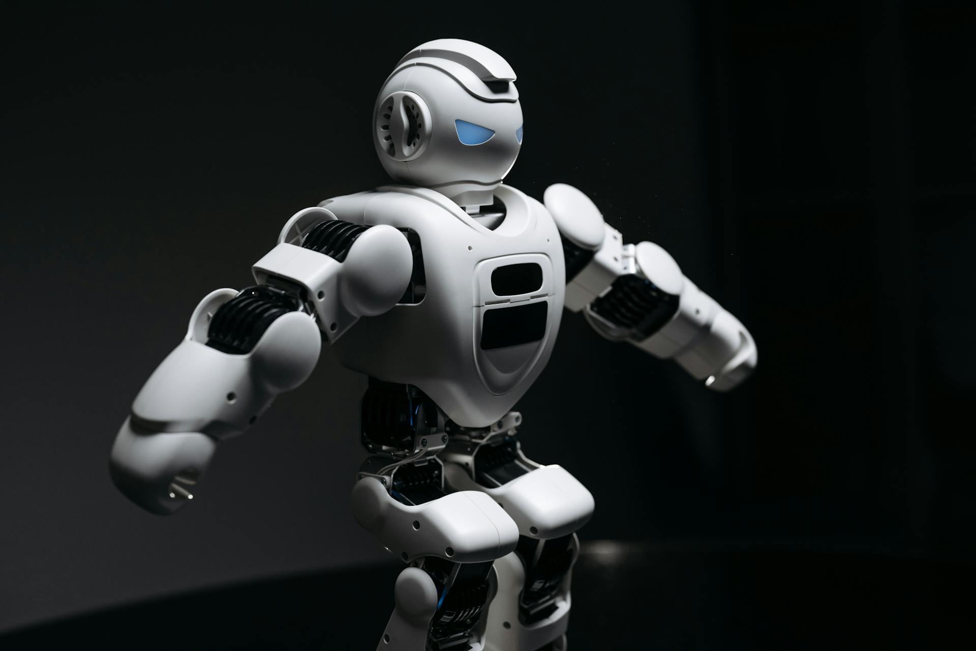 A White Robot Toy with Knees Bent