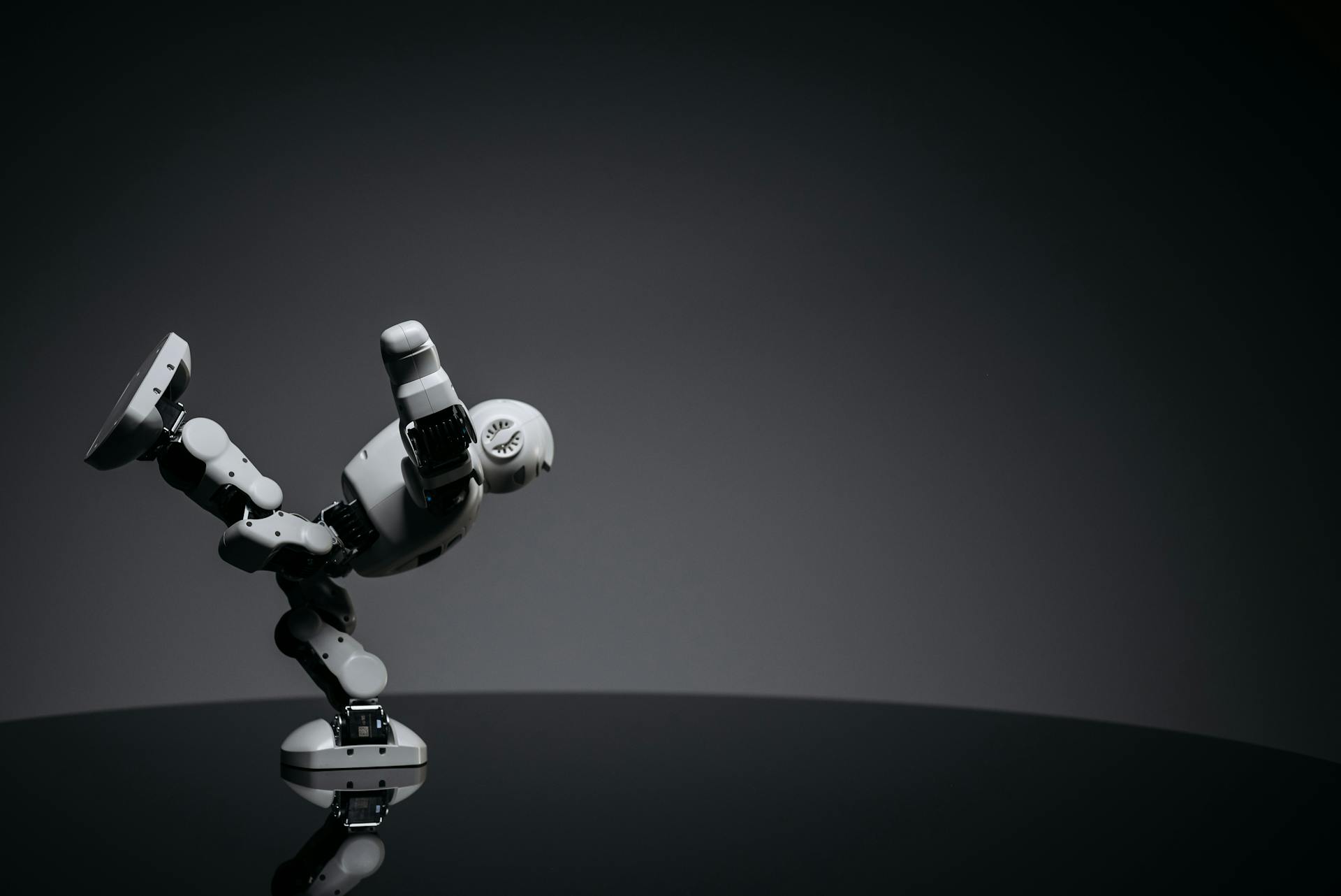 Close Up Shot of White Toy Robot on Black Surface