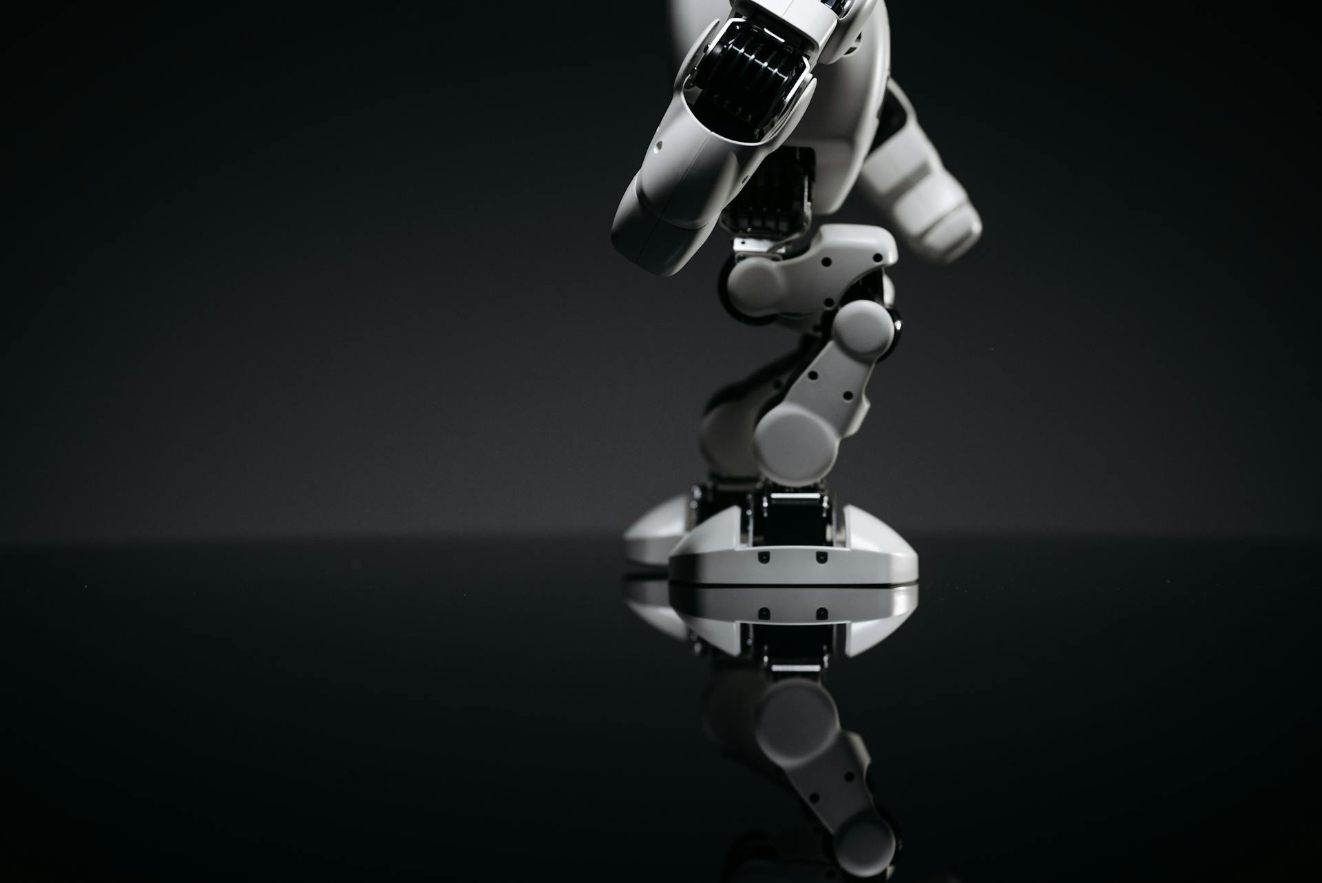 White Toy Robot on Black Surface