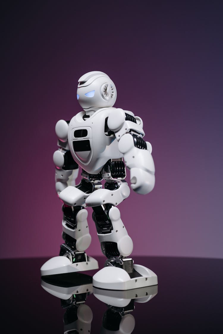 A White Robot Toy With Knees Bent
